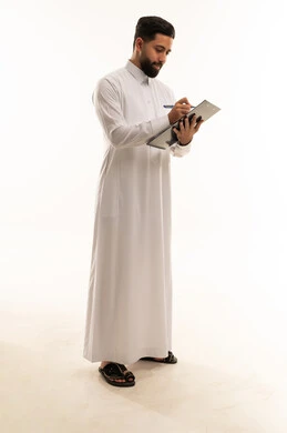 رجل سعودي بالثوب التقليدي يكتب على لوحة ملاحظات