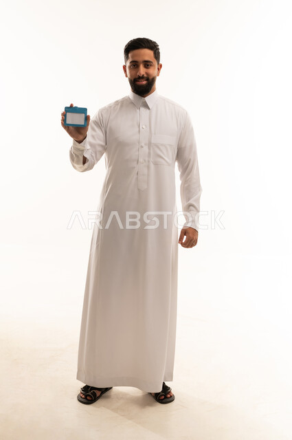 رجل سعودي يحمل بطاقة تعريف زرقاء في الاستوديو
