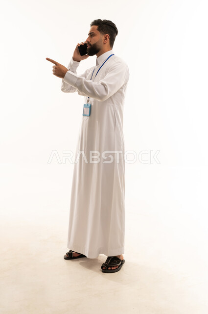 رجل أعمال سعودي يتحدث بالهاتف خلفية بيضاء
