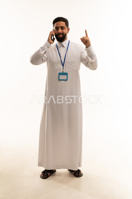 رجل أعمال سعودي بالثوب يتحدث بالهاتف في الاستوديو