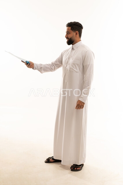 رجل سعودي بالثوب التقليدي يشير بقلم