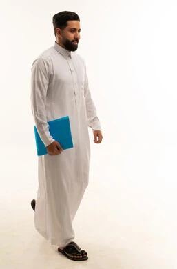 رجل سعودي يسير بالثوب الأبيض ويحمل ملف أزرق