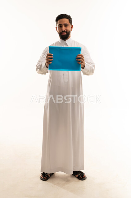 رجل سعودي بالثوب التقليدي يحمل ملف أزرق