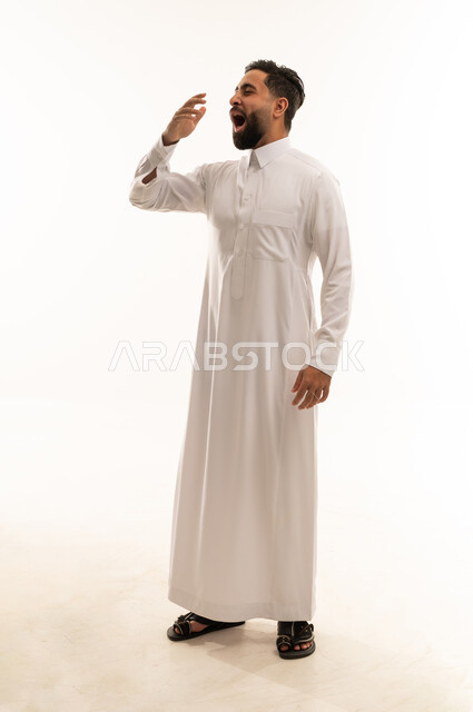 رجل سعودي بالثوب الأبيض يتثاءب بخلفية بيضاء