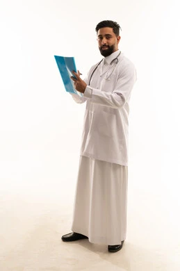 طبيب سعودي يحمل ملفاً طبياً أمام خلفية بيضاء