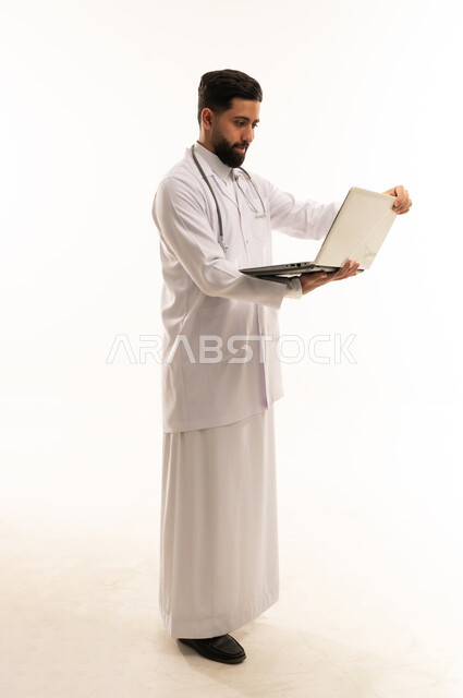 طبيب سعودي يستخدم جهاز كمبيوتر على خلفية بيضاء