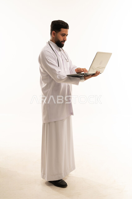 طبيب سعودي يستخدم الكمبيوتر المحمول بخلفية بيضاء