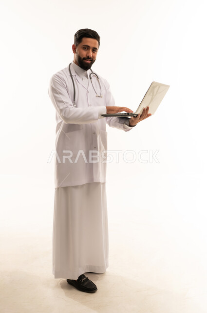 طبيب سعودي يستخدم الكمبيوتر المحمول بخلفية بيضاء