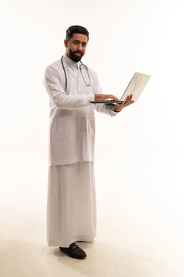 طبيب سعودي يستخدم الكمبيوتر المحمول بخلفية بيضاء