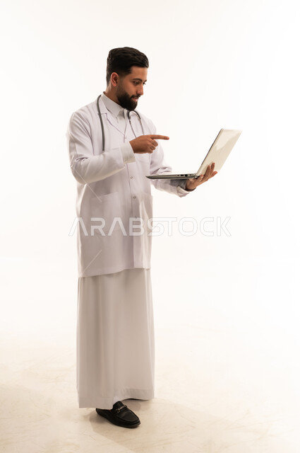 طبيب سعودي يشير إلى شاشة كمبيوتر محمول