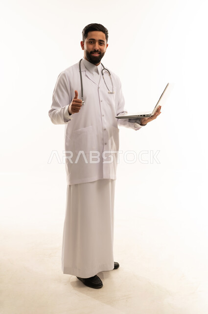 طبيب سعودي يحمل كمبيوتر محمول مع إيماءة الإعجاب