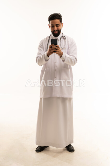 طبيب سعودي يستخدم الهاتف المحمول على خلفية بيضاء