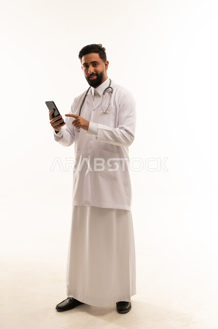 طبيب سعودي يمسك هاتف ذكي على خلفية بيضاء