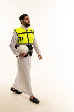 مهندس سعودي بالثوب وسترة السلامة على خلفية بيضاء