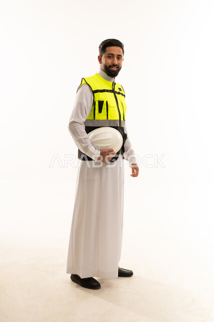 مهندس سعودي بسترة السلامة على خلفية بيضاء