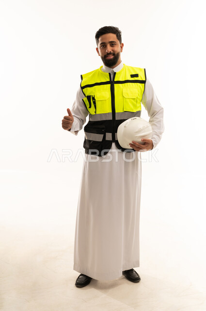 مهندس سعودي يرتدي سترة السلامة مع إيماءة النجاح