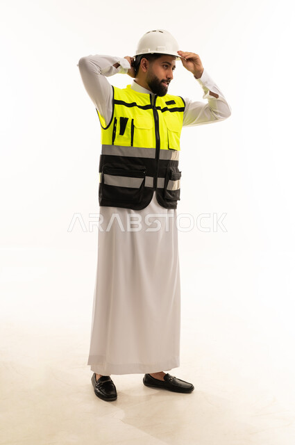 مهندس سعودي يرتدي سترة السلامة وخوذة الحماية