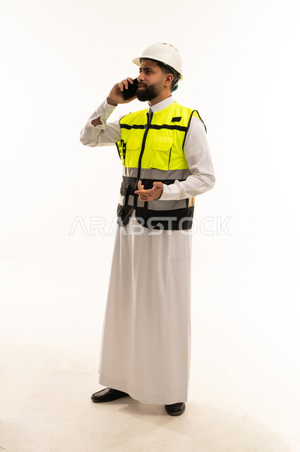 مهندس سعودي بملابس السلامة يتحدث عبر الهاتف