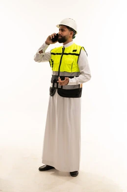 مهندس سعودي بملابس السلامة يتحدث عبر الهاتف