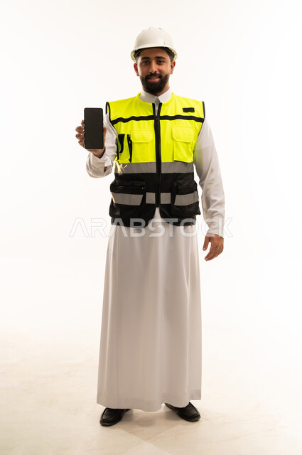 مهندس سعودي يحمل هاتف ذكي بخلفية بيضاء