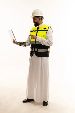 مهندس سعودي يحمل كمبيوتر محمول بملابس السلامة