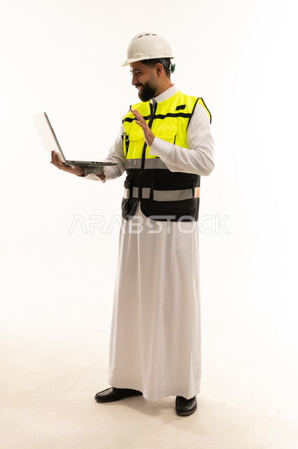 Saudi Engineer in Safety Vest Using Laptop