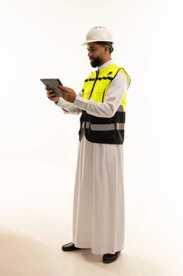مهندس سعودي بسترة السلامة يحمل جهاز لوحي