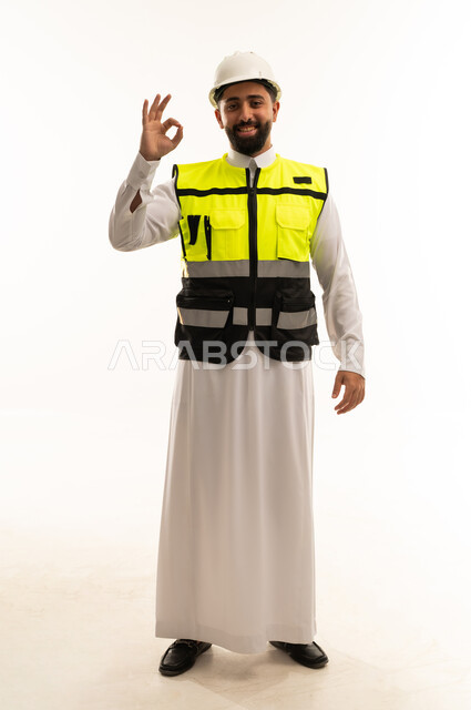 مهندس سعودي يرتدي سترة السلامة وخوذة الأمان