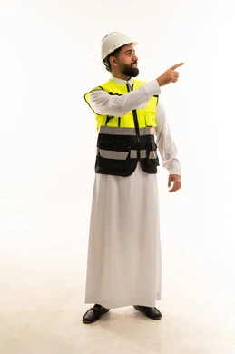 مهندس سعودي يرتدي ملابس السلامة ويشير على خلفية بيضاء