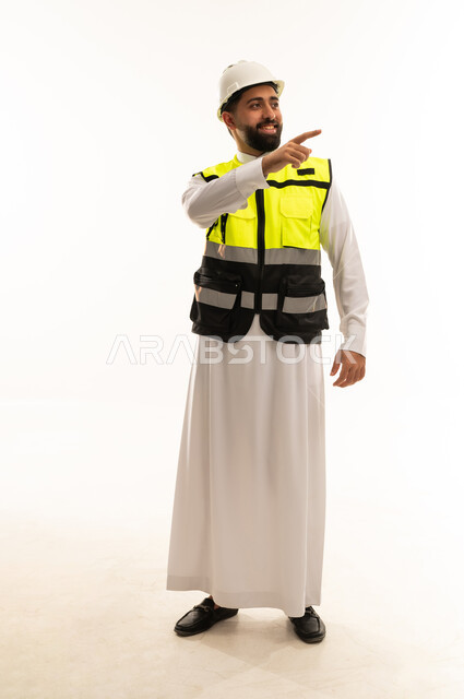 مهندس سعودي بزي السلامة يشير على خلفية بيضاء