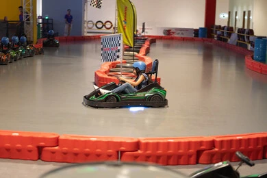 فتاة تقود سيارة كارتينج في مضمار سباق داخلي