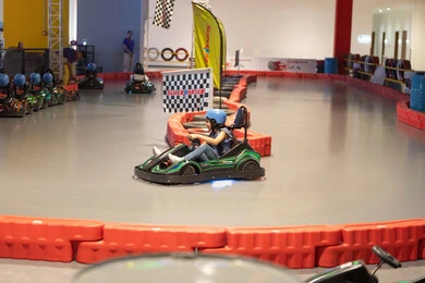 فتاة تقود سيارة كارتينج في حلبة سباق داخلية