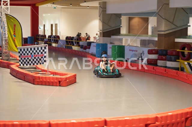 Arab Girl Driving Go-Kart on Indoor Racing Track