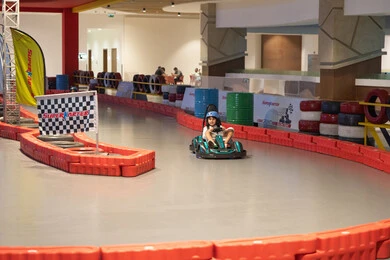 طفلة عربية تقود سيارة كارتينج في مضمار سباق داخلي