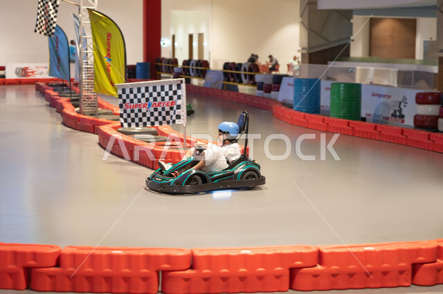 Saudi Boy Driving Go-Kart on Indoor Racing Track