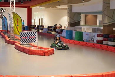 فتاة عربية تقود سيارة سباق في مضمار داخلي