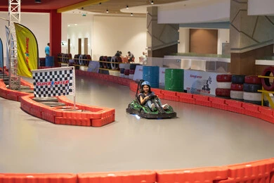 Arab Girl Driving Go-Kart on Indoor Racing Track