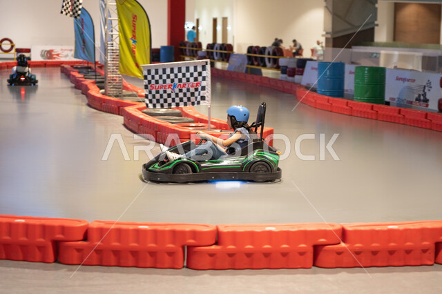 فتاة صغيرة تقود سيارة كارتينج في مضمار سباق داخلي