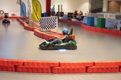 فتاة صغيرة تقود سيارة كارتينج في مضمار سباق داخلي