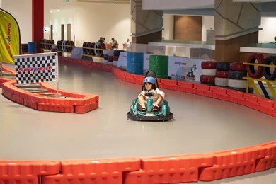 طفل سعودي يقود سيارة كارتينج في مضمار سباق داخلي