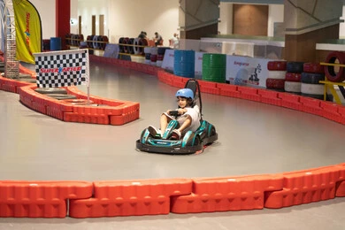 طفلة عربية تقود سيارة كارتينج في مضمار سباق داخلي