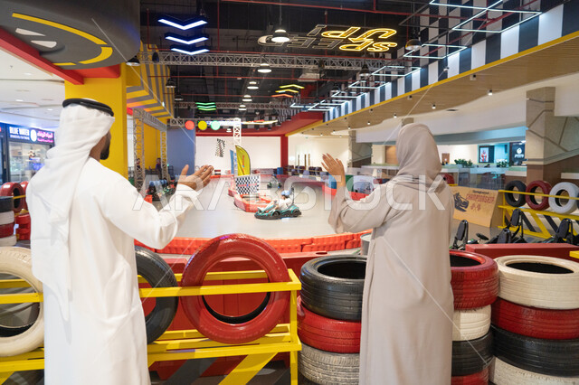Emirati Couple Watching Child Go-Kart Racing Indoor