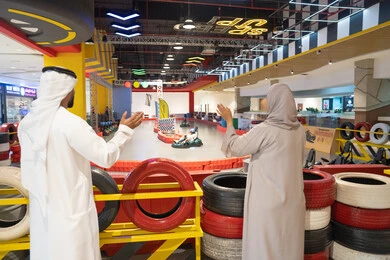 زوجان إماراتيان يشاهدان طفلاً في سباق الكارتينج