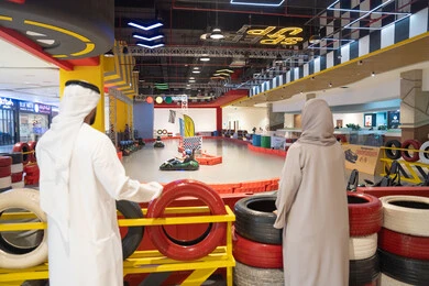 زوجان إماراتيان يشاهدان سباق الكارتينج في مركز ترفيهي