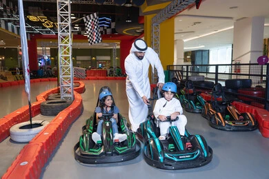 أب إماراتي وأطفاله في مضمار سباق سيارات الكارتينج