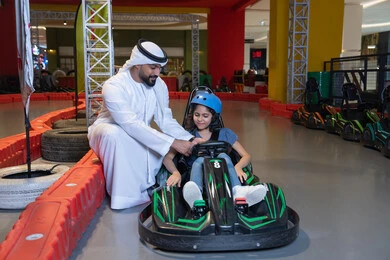 أب إماراتي وطفلته في حلبة سباق سيارات داخلية