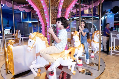 أطفال سعوديون يركبون لعبة الأحصنة الدوارة في مدينة ملاهي أطفال سعوديون يركبون لعبة الأحصنة الدوارة في مدينة ملاهي