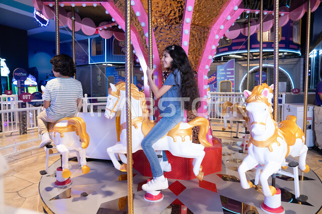 أطفال سعوديون في لعبة الخيول بمركز ترفيهي بالرياض