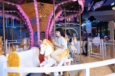 طفل عربي يركب لعبة الملاهي الدوارة في مركز ترفيهي