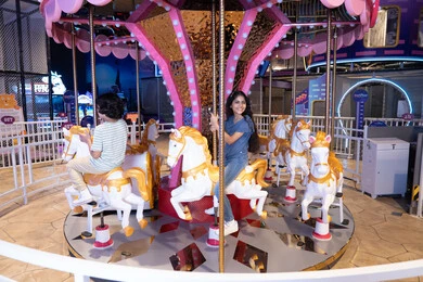 أطفال سعوديون يركبون لعبة الأحصنة في ملاهي مغلقة